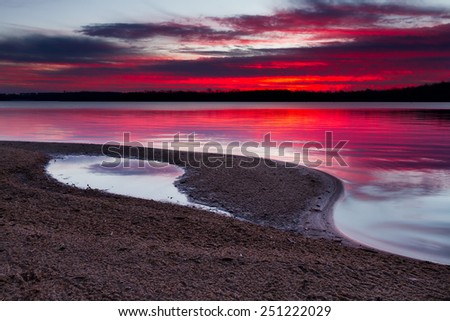 A horizontal image of sunrise on a sandy shoreline of Longview Lake.  Longview Lake is located just outside of the Kansas City, Missouri area.