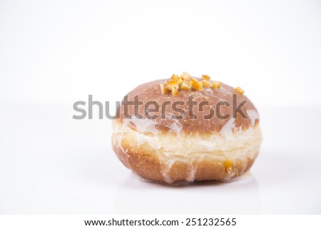 Fresh polish donut with jam, orange peel and icing isolated on white background