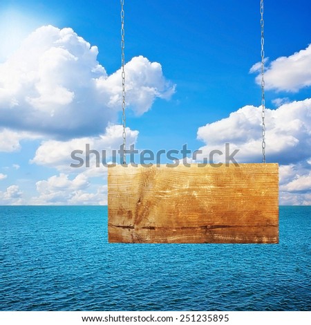 Sign board on chain hanging near see in summer sunny day