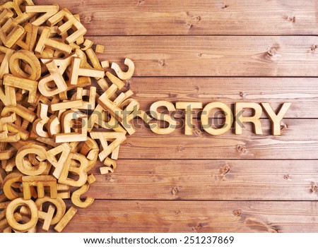 Word story made with block wooden letters next to a pile of other letters over the wooden board surface composition
