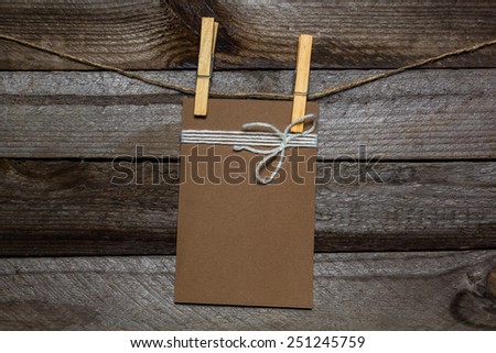 Message written on a paper hanging on the clothesline on wooden background 