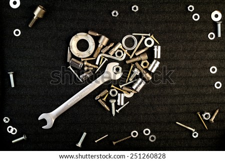 heart of theart of the tools and screw nuts on a dark gray background