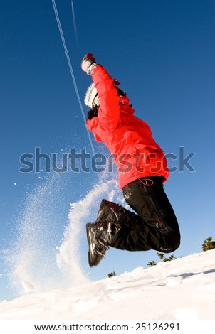 woman in red ski cloths jumping on snowy austrian slopes