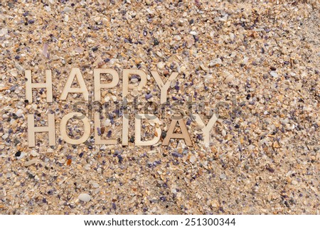 Happy Holiday concept made up with wooden letters on maritime pebble background.
