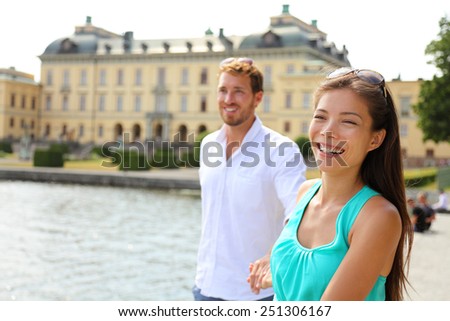 Stockholm couple at Drottningholm palace, Sweden. Tourist people visiting the Queen's royale residence in Stockholm, famous attraction in Sweden. Asian caucasian couple in Europe Scandinavia.