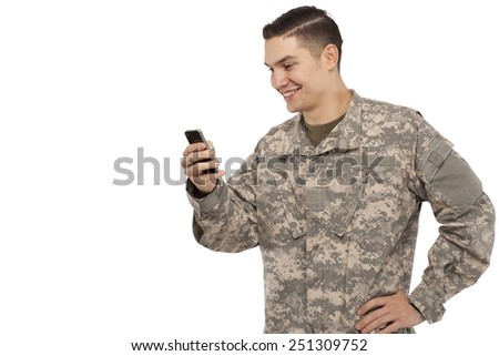 Side view of army soldier text messaging against white background