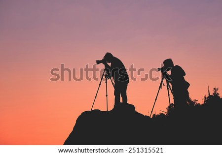 Silhouette of a photographers who shooting a sunset on the mountains