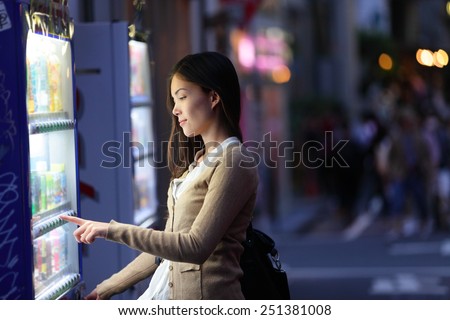 Japan vending machines - Tokyo woman buying drinks. Young student or female tourist choosing a snack or drink at vending machine at night in famous Harajuku district in Shibuya, Tokyo, Japan. Royalty-Free Stock Photo #251381008