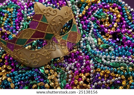 A group of Mardi Gras beads an mask with copy space