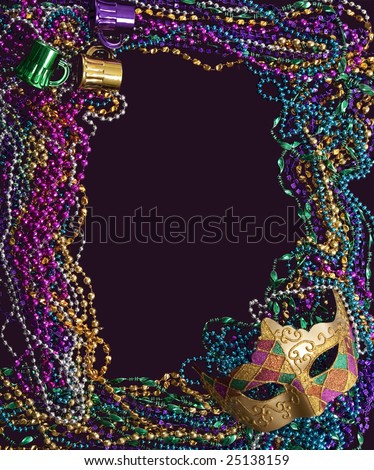 A group of Mardi Gras beads and mask making a frame with copy space on a purple background