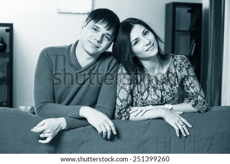 Couple leaning over their couch