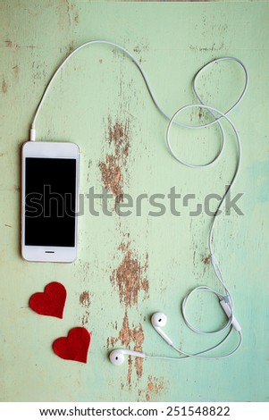 mobile phone with headphones on a wooden background