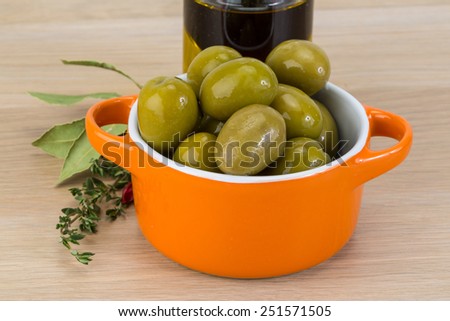 Green olives in the bowl with thyme branch 