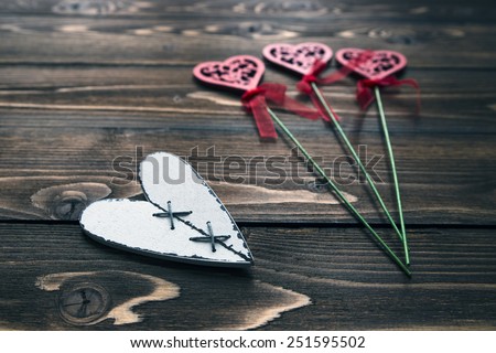 Postcard with wooden white heart and blurring decorative flowers on background