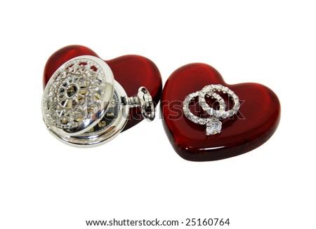 Diamond engagement ring with facets that sparkle brightly in the light symbolizing eternity of love, Red glass heart symbolizing love and romance, Silver pocket watch with a metal chain