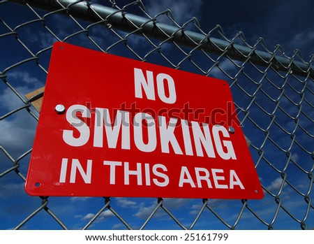 A red "No Smoking" sign isolated against a rich blue sky.