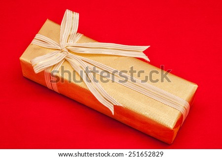 close up decorative golden gift box wrapping on red background