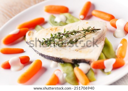 Swordfish grilled with mixed vegetables and yogurt sauce.