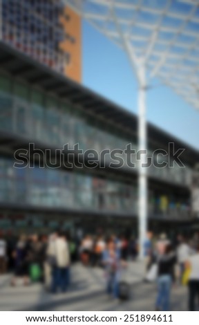 People enter a trade show. Intentionally blurred editing post production. Humans not recognizable.