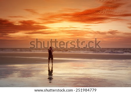 An image of a photographer at the sunset sea