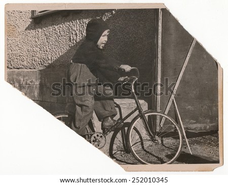 Old Black and white photographs, a little boy on a bicycle.