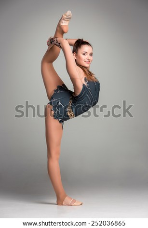 teenager doing gymnastics exercises  on a gray background
