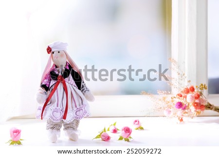 Handmade doll near window close-up