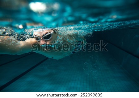 Male swimmer at the swimming pool.Underwater photo. Royalty-Free Stock Photo #252099805