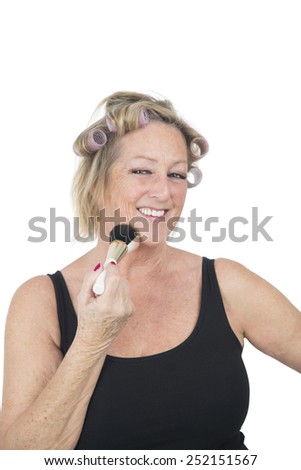 Beautiful blonde woman applying makeup on with a brush against a white background