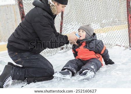 A family playing at the skating rink in winter.