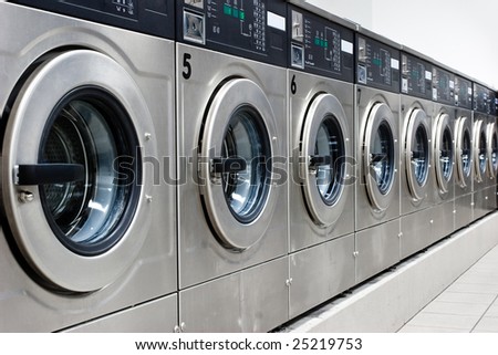 A row of industrial washing machines in a public laundromat Royalty-Free Stock Photo #25219753