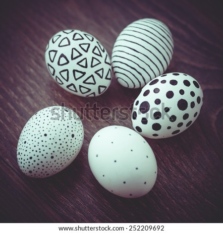 Modern painted easter eggs on wooden table. Toned picture