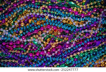 Background of large amount of marid gras bead on a purple background