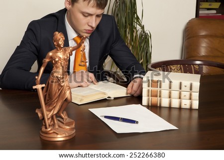 Lawyer reading a book in the office
