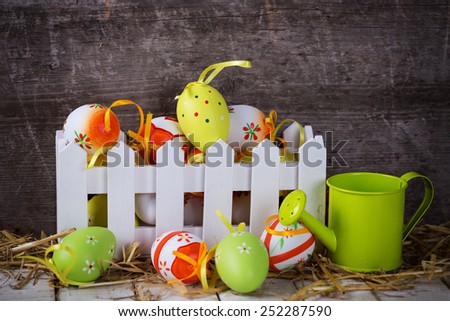 Colorful easter eggs in box on aged wooden background. Easter background.