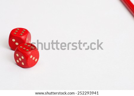 Dices and red pencil on a white paper. A minimalistic background