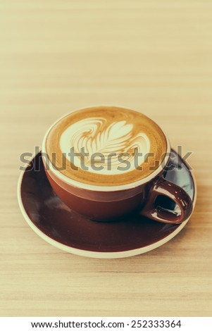 Latte coffee cup on wooden table - vintage effect style pictures