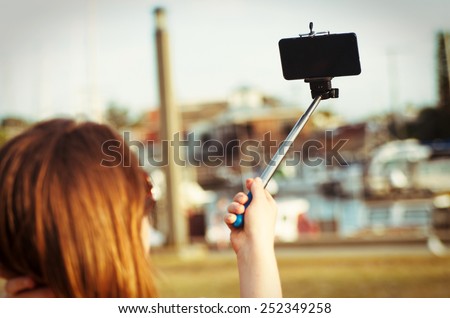 girl taking selfie picture outdoors.Focus on phone Royalty-Free Stock Photo #252349258