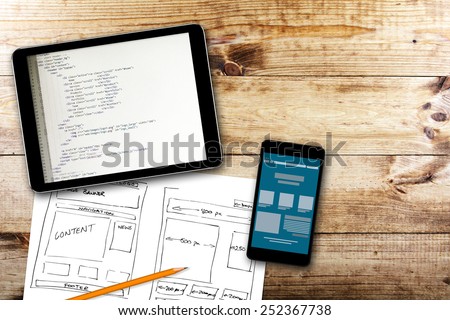 website wireframe sketch and programming code on digital tablet Royalty-Free Stock Photo #252367738
