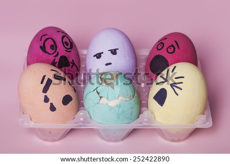 Bunch of painted eggs reacting to dead broken egg