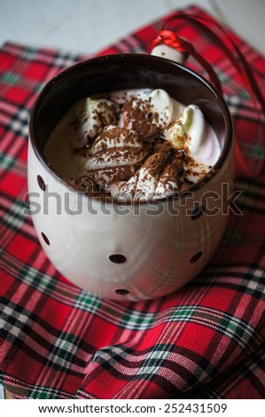 Cloeup of hot chocolate with marshmallows in a mug on napkin