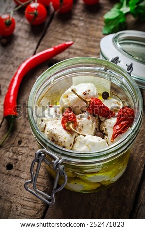 laban - yougurt or cheese bals with olive oil and spices in glass jar on wooden background