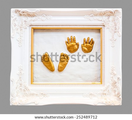 Baby hand and foot print in gypsum in a gold frame.