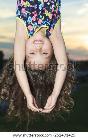 A upside down little girl at the sunset