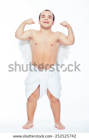 Love is almighty. Full length portrait of an adorable little cupid showing his biceps while standing isolated with copy space