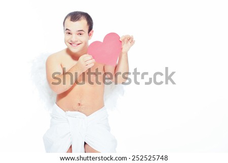 Bringing the love this Valentines. Portrait of an adorable little cupid holding a paper heart while standing isolated on the table with copy space