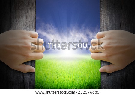 Thank you word. Hand opening an old wooden door and found a texts floating over green field and bright blue Sky Sunrise.