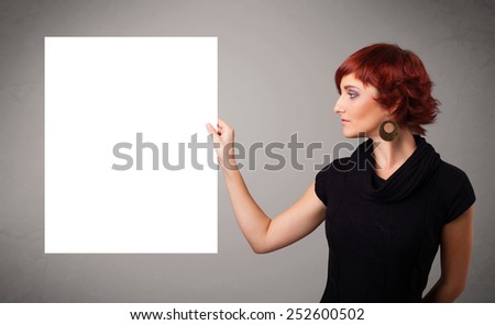 Pretty young woman presenting white paper copy space