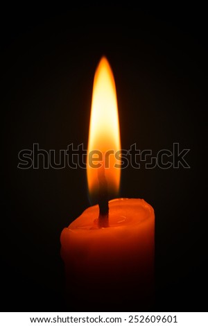 Candle flame closeup isolated on black.