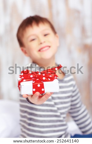 Happy birthday, daddy. Selective focus image of a little child in pajama stretching out a birthday gift and smiling
